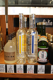お店の棚に並んだ「Haamonii Shochu」、右の青いラインのボトルはオリジナル焼酎。